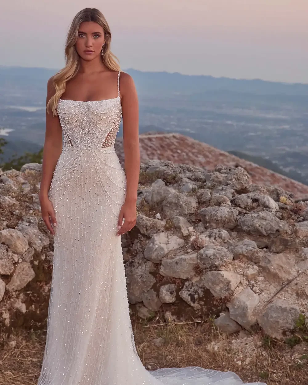 model is wearing a lace sleeveless open back bridal gown