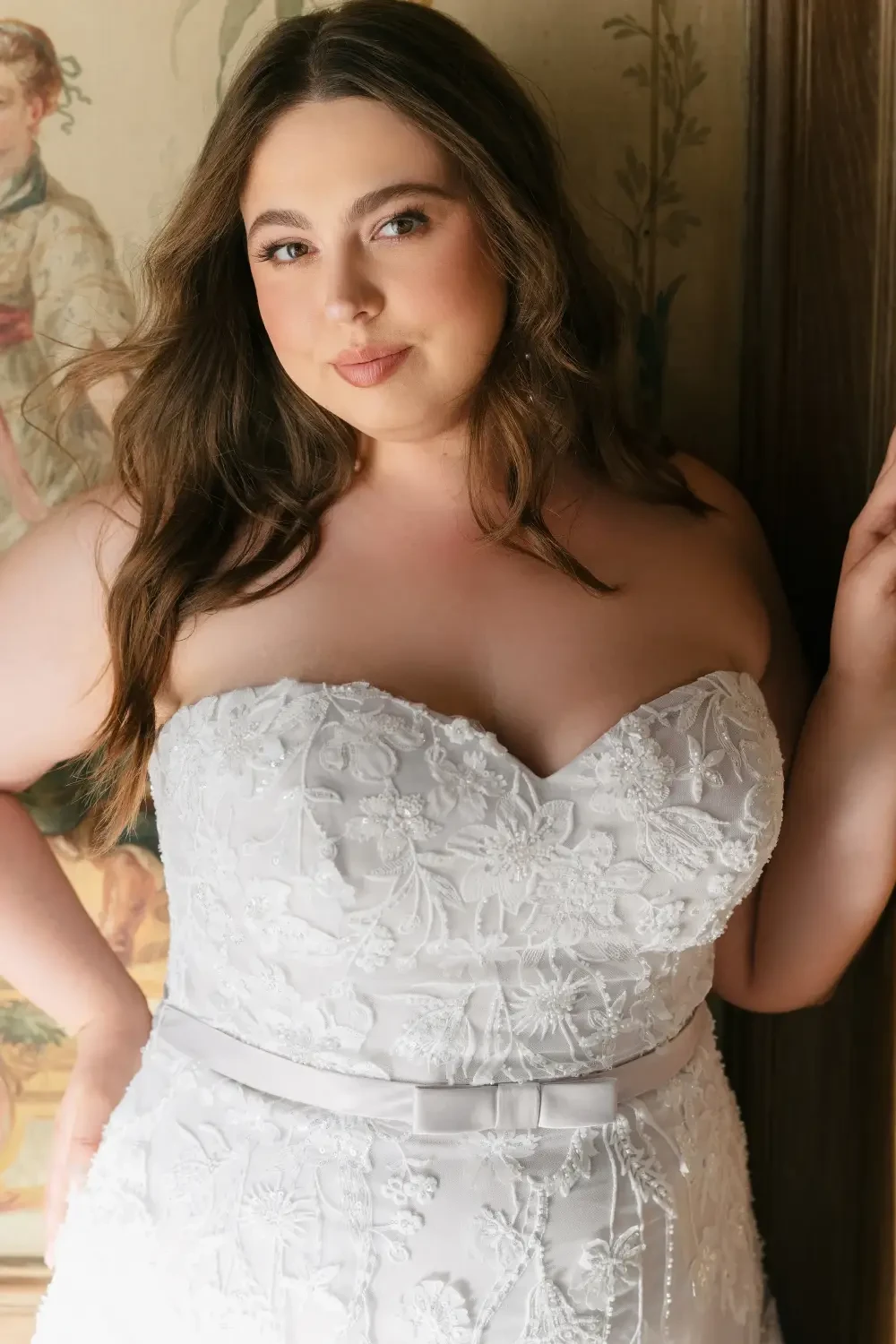 model is wearing a plus size strapless bridal gown